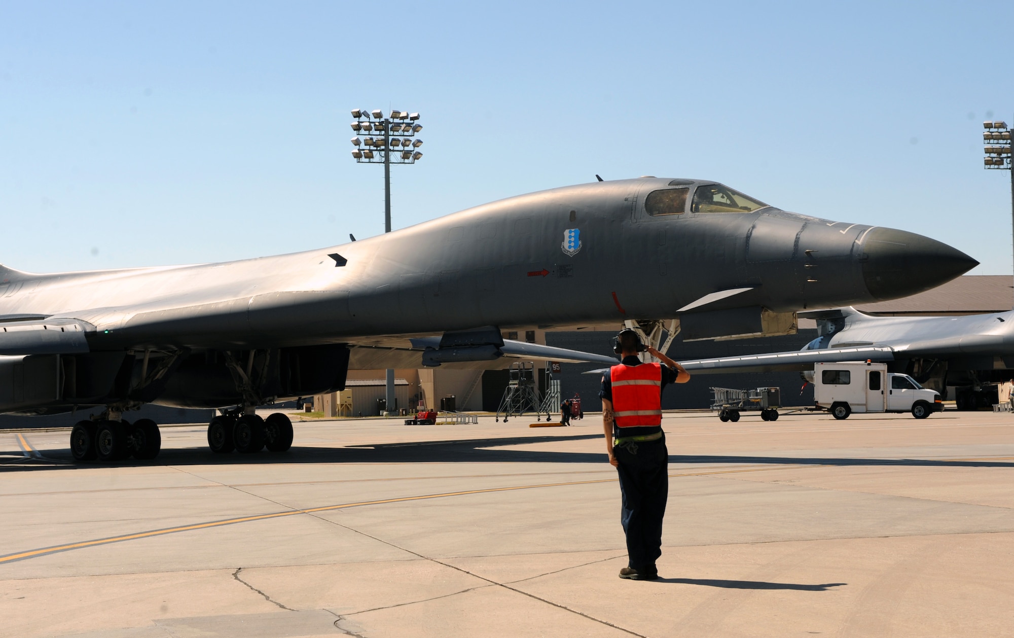 An Airman from the 37th Aircraft Maintenance Unit marshals a B-1 bomber out to the flightline at Ellsworth Air Force Base, S.D., to perform a flyover in honor of U.S. Army Air Corps Staff Sgt. David Thatcher, June 27, 2016. Thatcher, one of the last remaining Doolittle Raiders, passed away from complications of a stroke on June 22. (U.S. Air Force photo by Airman 1st Class Denise M. Nevins/Released)