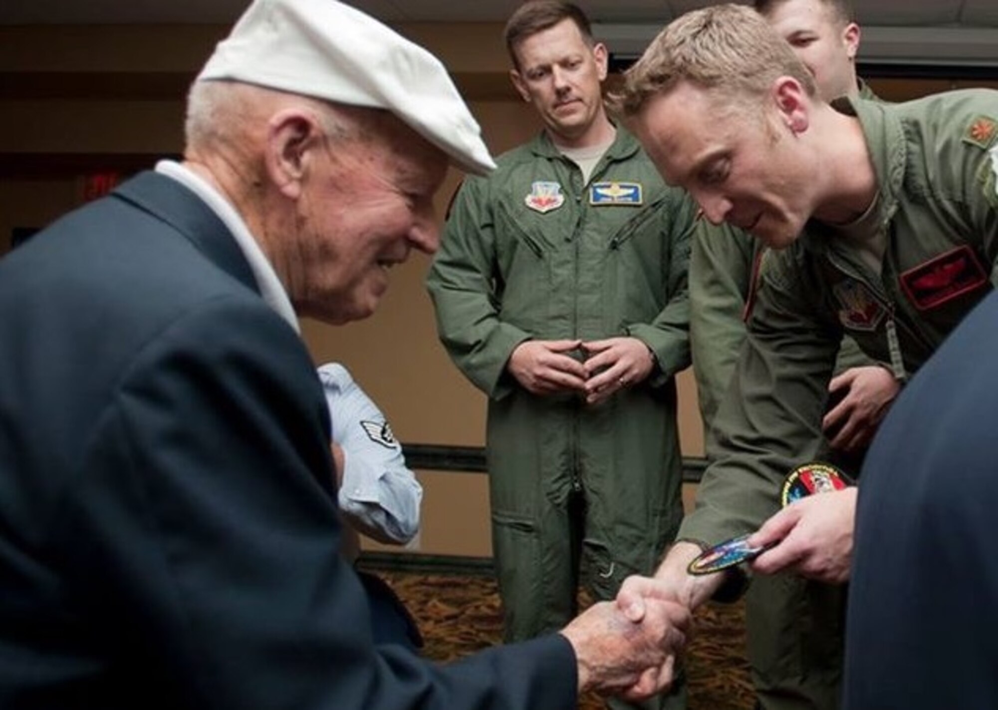 U.S. Army Air Corps Staff Sgt. David Thatcher, left, receives a recent B-1 bomber deployment patch during the Final Doolittle Raider Toast in November 2013. Following the Doolittle Raid, Thatcher served in England and Africa until January 1944, flying in a B-26 bomber in 26 missions over North Africa and Europe, including the first bombing raid over Rome. (Courtesy photo/Released)