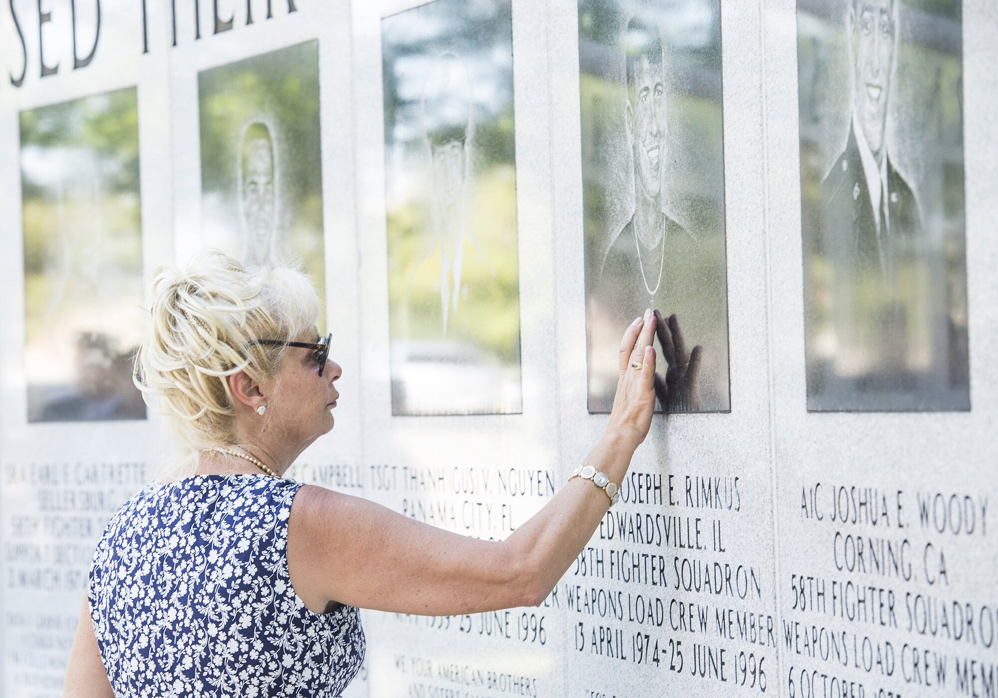 Dari Bradley, aunt of Airman 1st Class Joseph Rimkus, touches a portrait of him on the Khobar Towers Memorial wall June 24, after the a memorial ceremony at Eglin Air Force Base, Fla. Rimkus was a weapons load crewmember from the 58th Tactical Fighter Squadron who lost his life as a result of the Khobar Towers bombing June 25, 1996. (U.S. Air Force photo/Senior Airman Stormy Archer)