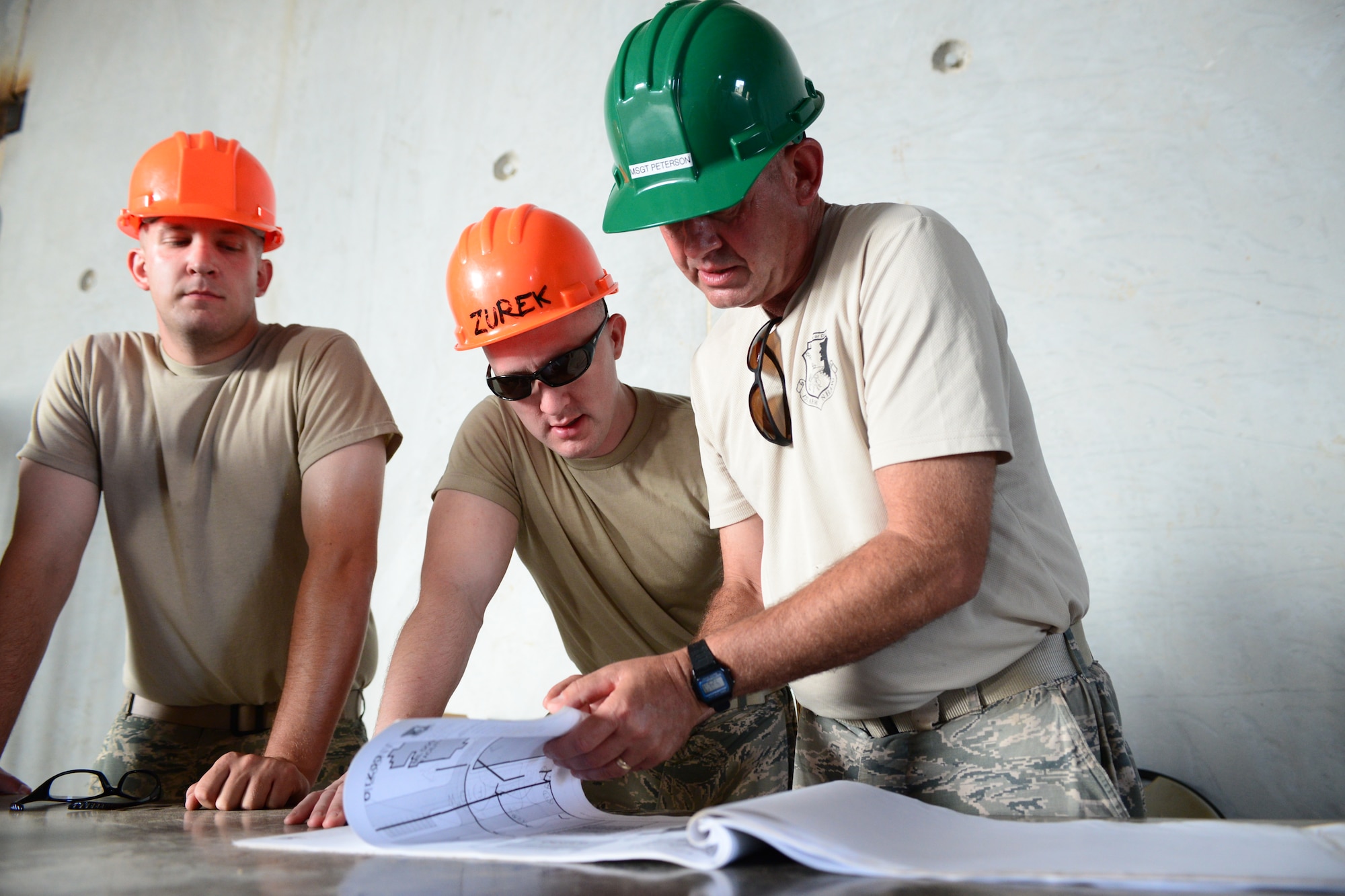From the left, Airman First Class Matthew Johnson, Staff Sgt. William Zurek, and Master Sgt. Daniel Peterson with the 157th Civil Engineering Squadron review design plans for construction of the Commando Warrior Field Training Facility Anderson Air Force Base, Guam, June 20, 2016. 157CES Airmen are deployed to Guam for annual where they are working on a construction project for the Pacific Command Regional Training Center. (Air National Guard photo by Airman 1st Class Ashlyn J. Correia)