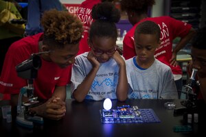 Children gather around an experiment during the opening of the Center of Innovation at the Joint Base Andrews Youth Center, here, June 24, 2016. The center will be available to approximately 140 children from the ages of 12-19 and can hold 25 students at any given time. (U.S. Air Force photo by Senior Airman Mariah Haddenham)