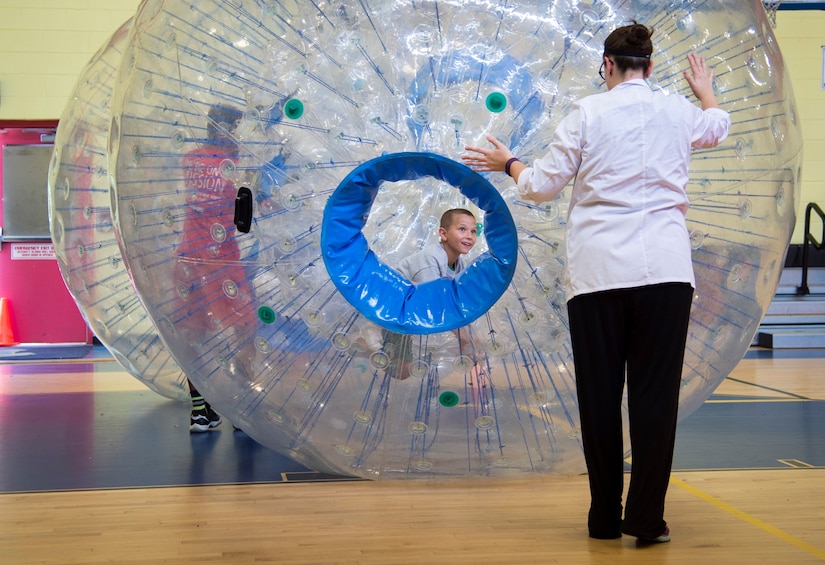 Cortney Wieber, Science from Scientists director of education, rolls a Zorb ball during opening of the Center of Innovation at the Joint Base Andrews Youth Center, here, June 24, 2016. The center’s goal is to excite children about science, technology, engineering, and math subjects, also known as STEM. (U.S. Air Force photo by Senior Airman Mariah Haddenham)