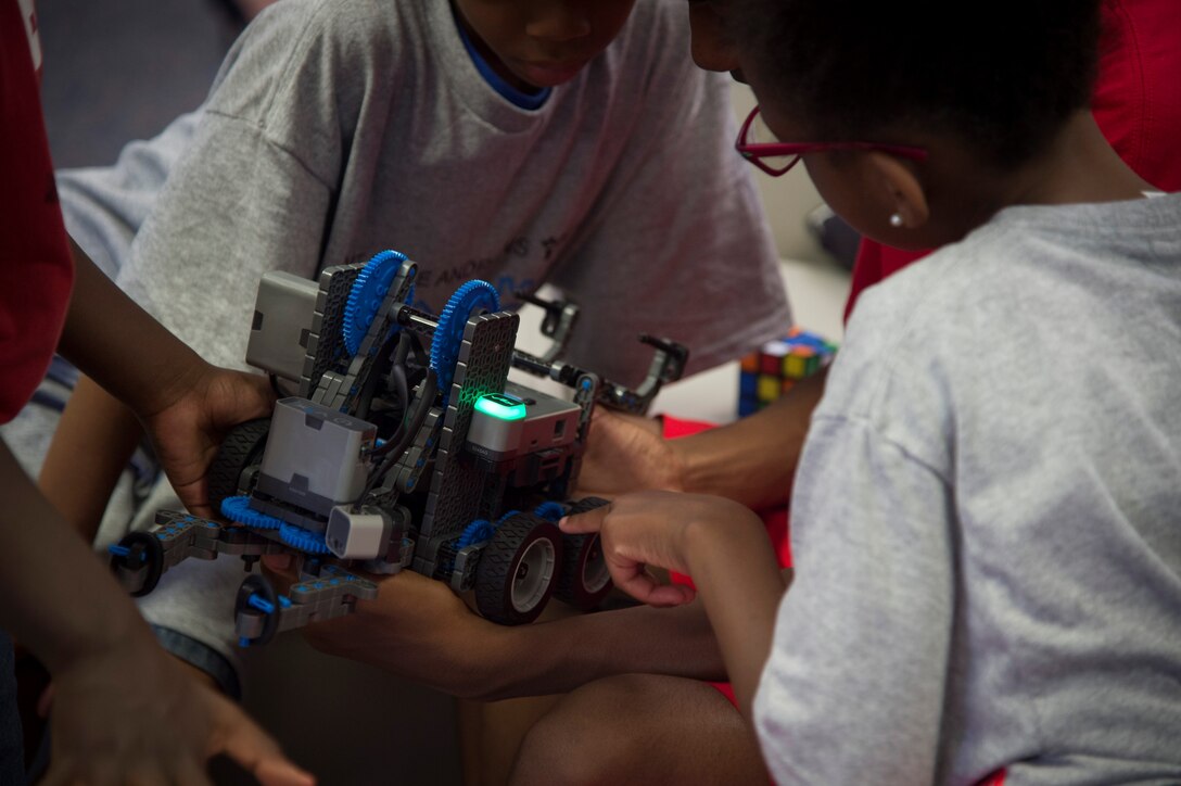 Children play with a model robot during the opening of the Center of Innovation at the Joint Base Andrews Youth Center, here, June 24, 2016. The center’s goal is to excite children about science, technology, engineering, and math, also known as STEM subjects. (U.S. Air Force photo by Senior Airman Mariah Haddenham) 