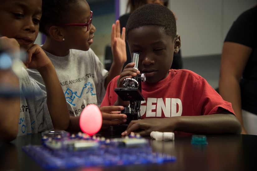 A child looks through a microscope during the opening of the Center of Innovation at the Joint Base Andrews Youth Center, here, June 24, 2016. The center is one of 20 like it around the world, allowing children from military families the chance to get interested in science, technology, engineering, and math subjects. (U.S. Air Force photo by Senior Airman Mariah Haddenham)