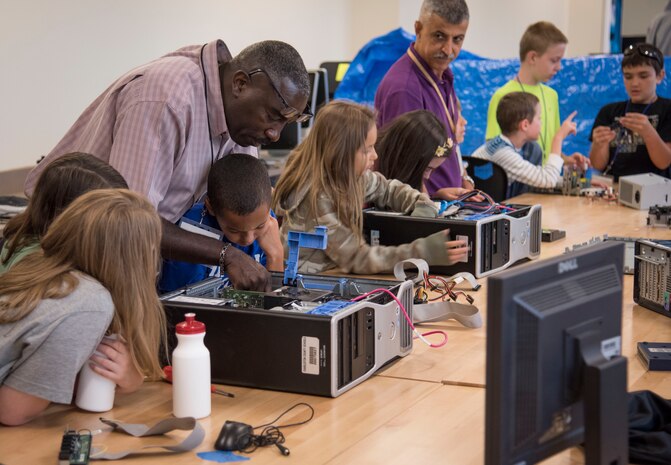 James Bouie and Mo Dauod teach computer deconstruction during the SPAWAR Systems Center (SSC) Atlantic sponsored cybersecurity summer camp at the Lowcountry Tech Academy of Charleston County in Charleston, S.C. Over 30 volunteers from SSC Atlantic exposed and challenged more than 80 middle school students in cyber espionage, computer deconstruction, command and control systems, Internet security, snap circuits and scratch programming, among other activities, during the week long camp. (U.S. Navy photo/Joe Bullinger)