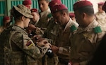 A British soldier with the Royal Army Medical Corps helps an Iraqi soldier enrolled in the Junior Leaders Course (JLC) prepare a tourniquet during a skills evaluation at Camp Taji, Iraq, earlier this year. (U.S. Army photo by Sgt. Paul Sale) 