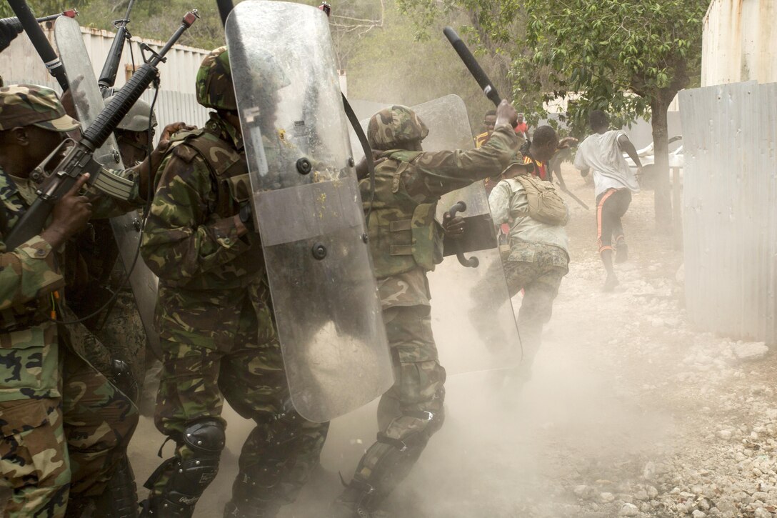 Service members from several partner nations fend off role players acting as rioting villagers as part of crowd control training during Tradewinds 2016 at Twickenham Park Gallery Range, Jamaica, June 25, 2016. Tradewinds is a Carribbean-focused multinational training exercise with maritime and land phases aimed at improving security and disaster relief assistance. Marine Corps photo by Cpl. Justin T. Updegraff
