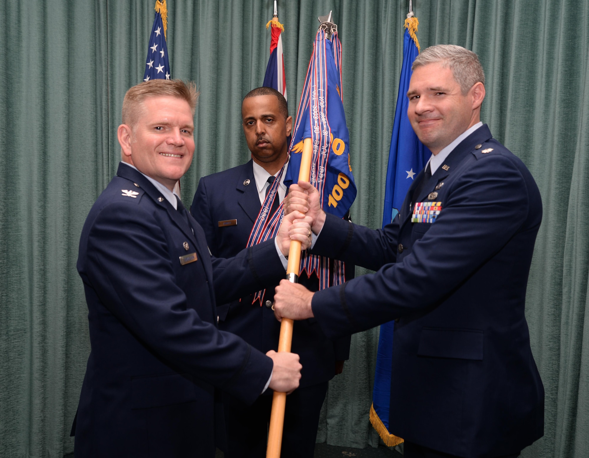 U.S. Air Force Col. Thomas Torkelson, 100th Air Refueling Wing commander, passes the 100th Comptroller Squadron guidon to U.S. Air Force Lt. Col. Christopher Boyd, incoming 100th CPTS commander, June 27, 2016, on RAF Mildenhall, England. Boyd previously served as the U.S. Air Attaché in Bucharest, Romania. (U.S. Air Force photo by Senior Airman Christine Halan/ Released)