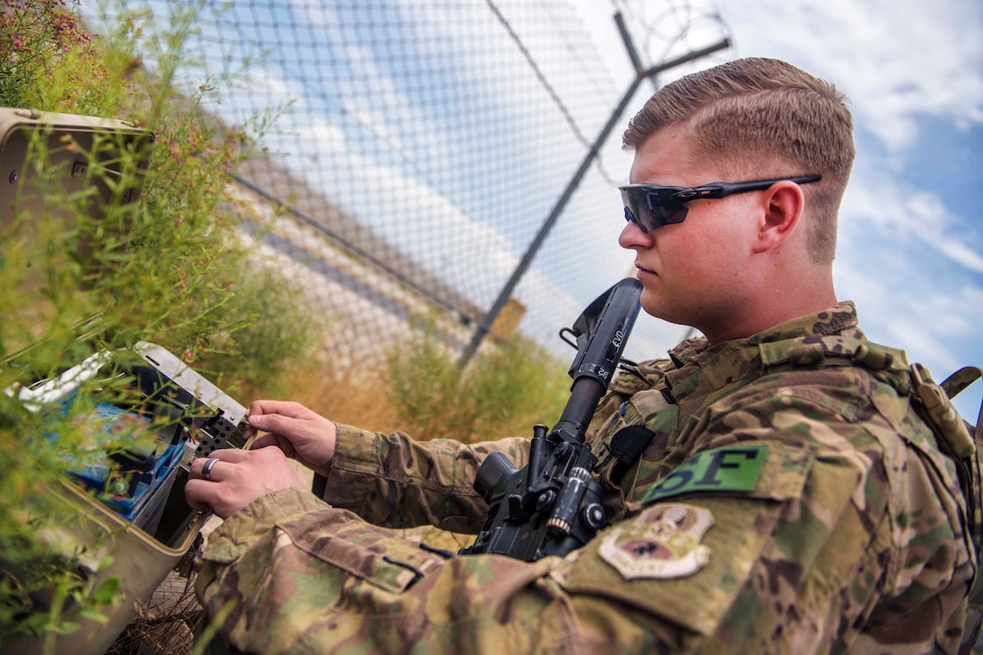 Air Force Senior Airman Michael Van Deusen checks the power box of the tactical automated security system or TASS, at Bagram Airfield, Afghanistan, June 27, 2016. The TASS system detects movement on the flightline perimeter fencing and relays that information to a joint operations center. Deusen is assigned to the 455th Expeditionary Security Forces Squadron, quick reaction force. Air Force photo by Senior Airman Justyn M. Freeman