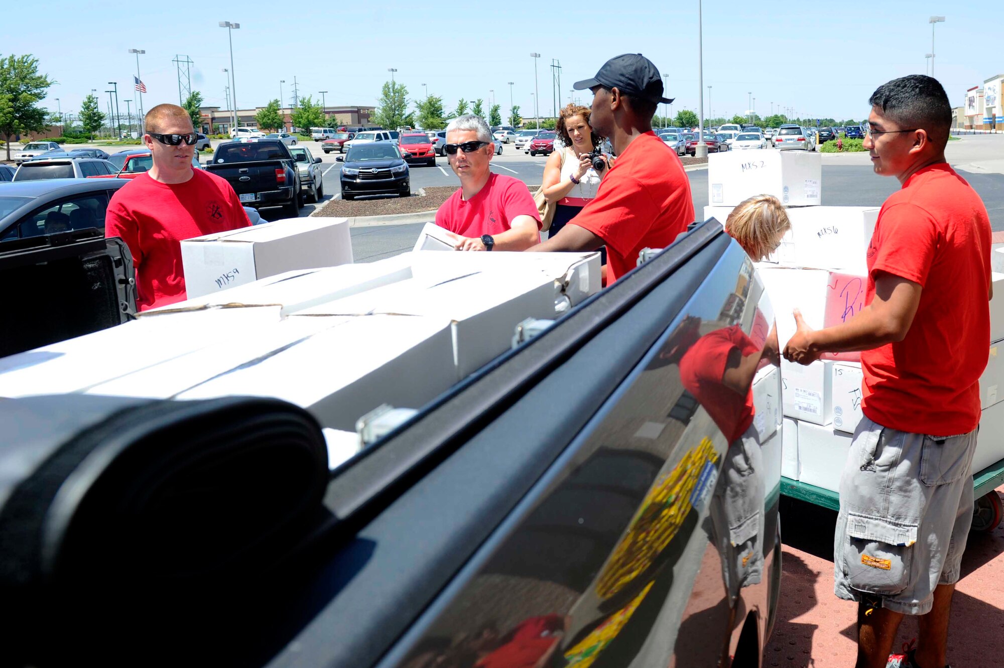 Airmen from the 22nd Maintenance Squadron load ribs unto a truck, June 21, 2016, in Derby, Kansas. The squadron collected more than 800 slabs of ribs donated by Dillons customers in a combined effort with the USO, during the Honor Our Heroes campaign. (U.S. Air Force photo/Senior Airman David Bernal Del Agua)