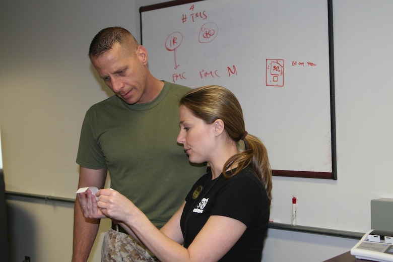 Lauren King, Semper Fit dietitian, goes over Gunnery Sgt. William Norris's body composition results. Body composition, blood pressure, and bone density screenings were offered as part of Training and Education's Health and Wellness Week June 7. 