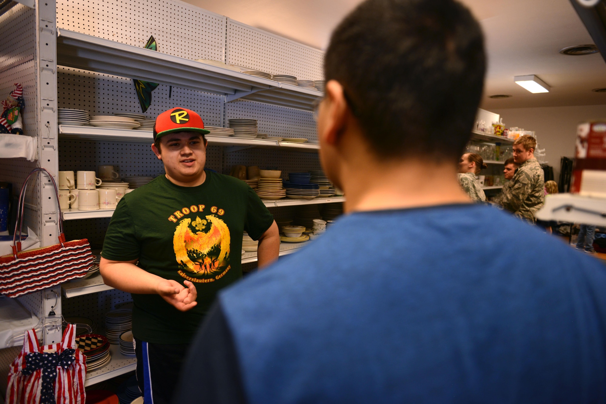 Wesley Reagan, Airman’s Attic volunteer, speaks with a customer at Ramstein Air Base, Germany, June 24, 2016. Reagan is a member of the Boy Scouts of America, Troop 69. (U.S. Air Force Photo/ Airman 1st Class, Joshua Magbanua)