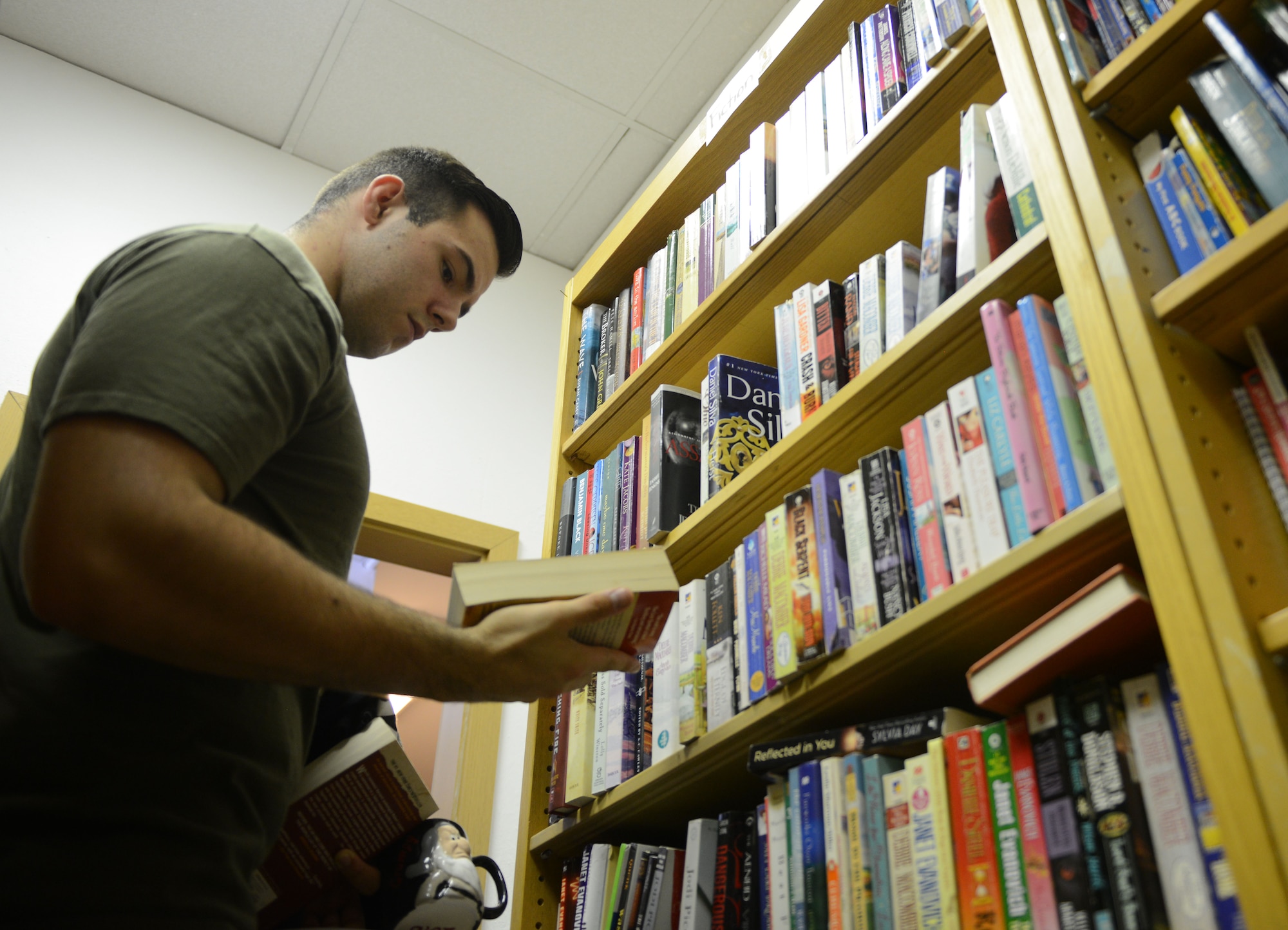 Airman 1st Class Jacob Fraas, 721st Aircraft Maintenance Squadron crew chief, looks at books being given away at the Airman’s Attic at Ramstein Air Base, Germany, June 24, 2016. The Airman’s Attic offers a wide range of household goods, clothing, electronics and toys to active duty military members E-5 and below. (U.S. Air Force Photo/ Airman 1st Class Joshua Magbanua)
