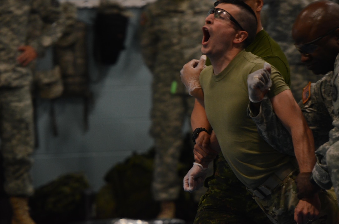 U.S. Army Master Sgt. Michel Sauret with the 200th Military Police Brigade's Public Affairs Office from Fort Meade, Md., takes a break from recording the action to experience the power of the X26E Taser during Guardian Justice at Fort McCoy, Wisc., June 22, 2016. Guardian Justice is a military exercise which focuses on training both American and Canadian military police forces in detainee operations and non-lethal weapons applications. (U.S. Army photo by Spc. Adam Parent)