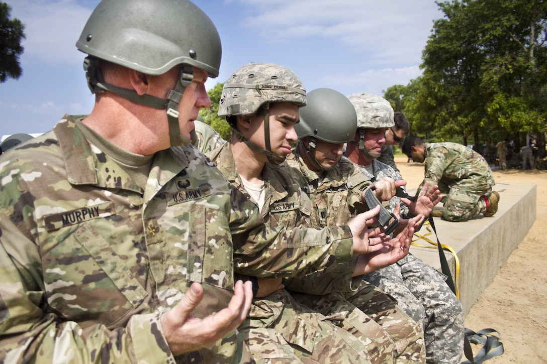 Maj. Christopher Murphy, Commander of the 982nd Combat Camera Company, and paratroopers from the U.S. Army Civil Affairs & Psychological Operations Command (Airborne), practice actions in the aircraft prior to an airborne operation over St. Mere Eglise drop zone near Fort Bragg, N.C. on June 25, 2016. The United States Army Civil Affairs & Psychological Operations Command (Airborne), an Army Reserve unit, conducts airborne operations in order to maintain currency and proficiency. USACAPOC(A) supports the Army and Joint Force with strategic, operational, and tactical civil affairs, military information support, and information operations capabilities across the range of military operations. (U.S. Army photo by Staff Sgt. Felix Fimbres)