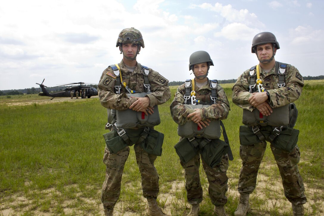 982nd Combat Camera Company paratroopers: Sgt. Austin Berner, Spc. Kristen Root, and Spc. Micheal Cox, pose for a group picture prior to their jump onto St. Mere Eglise drop zone near Fort Bragg, N.C. on June 25, 2016. The 982nd, an Army Reserve unit, provides our military leaders and government officials first-hand, still and video imagery (both released and classified), of our forces in the field. They are the "Eyes and Ears" of the decision makers.  (U.S. Army photo by Staff Sgt. Felix Fimbres)