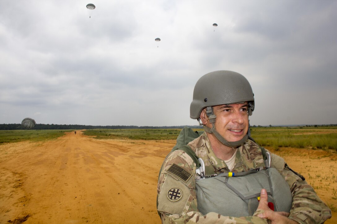 Capt. Loren Teillon, 982nd Combat Camera Company, walks off St. Mere Eglise drop zone after a successful jump at Fort Bragg, N.C. on June 25, 2016. The 982nd, an Army Reserve unit, provides our military leaders and government officials first-hand, still and video imagery (both released and classified), of our forces in the field. They are the "Eyes and Ears" of the decision makers.  (U.S. Army photo by Staff Sgt. Felix Fimbres)