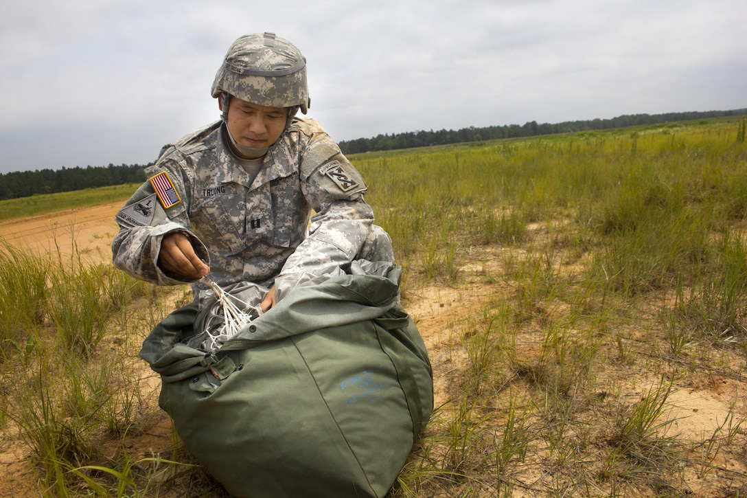 Capt. Houng Truong, Commander of the 824th  Quartermaster Company, packs his parachute after a successful jump onto St. Mere Eglise drop zone near Fort Bragg, N.C. on June 25, 2016. The 824th provided support for the operation hosted by the U.S. Army Civil Affairs & Psychological Operations Command (Airborne). USACAPOC(A), an Army Reserve unit, conducts airborne operations in order to maintain currency and proficiency. USACAPOC(A) supports the Army and Joint Force with strategic, operational, and tactical civil affairs, military information support, and information operations capabilities across the range of military operations. (U.S. Army photo by Staff Sgt. Felix Fimbres)