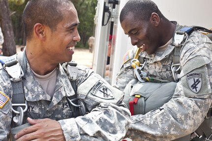 Staff Sgt. Chatchai Brunosky gets help hooking up his reserve parachute from Capt. Robert Gammage prior to an airborne operation over St. Mere Eglise drop zone near Fort Bragg, N.C. on June 25, 2016. Both Soldiers are assigned to the U.S. Army Civil Affairs & Psychological Operations Command (Airborne); an Army Reserve unit. USACAPOC(A) conducts airborne operations in order to maintain currency and proficiency. USACAPOC(A) supports the Army and Joint Force with strategic, operational, and tactical civil affairs, military information support, and information operations capabilities across the range of military operations. (U.S. Army photo by Staff Sgt. Felix Fimbres)