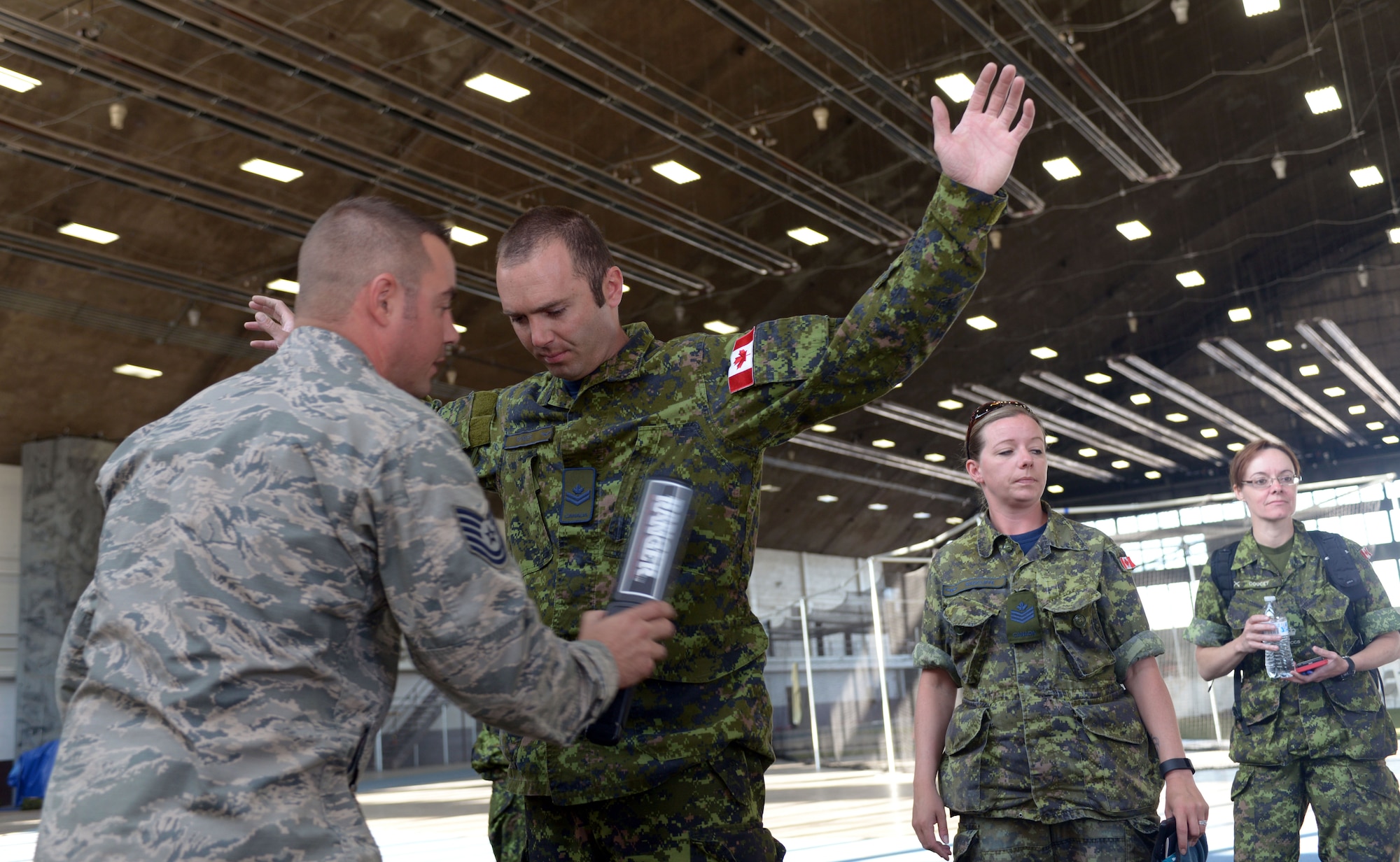 Airmen of the 28th Logistics Readiness Squadron assist members of the 41 Canadian Brigade Group with outprocessing in the Pride Hangar at Ellsworth Air Force Base, S.D., June 23, 2016. Known as Task Force 41, personnel renovated buildings on Camp Rapid and participated in specialty-specific training such as convoy escorts, dismounted battle movements and urban terrain operations. (U.S. Air Force photo by Airman Donald Knechtel/Released)