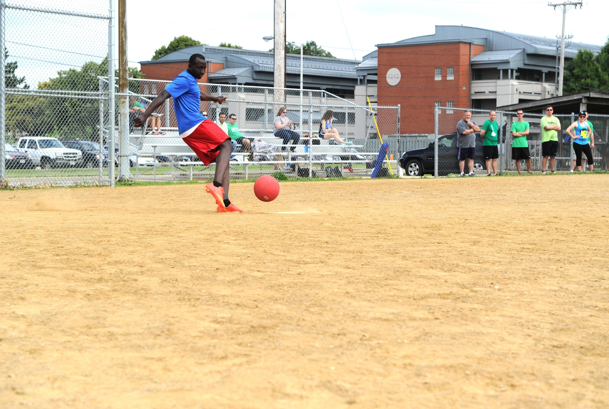 A member of the National Air and Space Intelligence Center strikes the ball during a kick ball game that was part of the Center's annual Sports Fest competition on Wright-Patterson Air Force Base, Ohio, June 17, 2016. (U.S. Air Force photo/Senior Airman William K. Veyon)