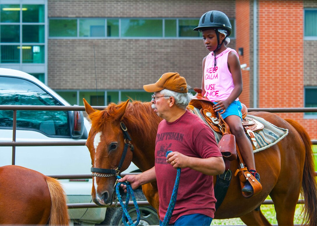 A child rides a horse during the National Air and Space Intelligence Center's annual Sports Fest on Wright-Patterson Air Force Base, Ohio, June 17, 2016. The fest included a variety of sports ranging from basketball to rally races along with activities to entertain young family members. (U.S. Air Force photo/Tech. Sgt. Eunique P. Thomas)