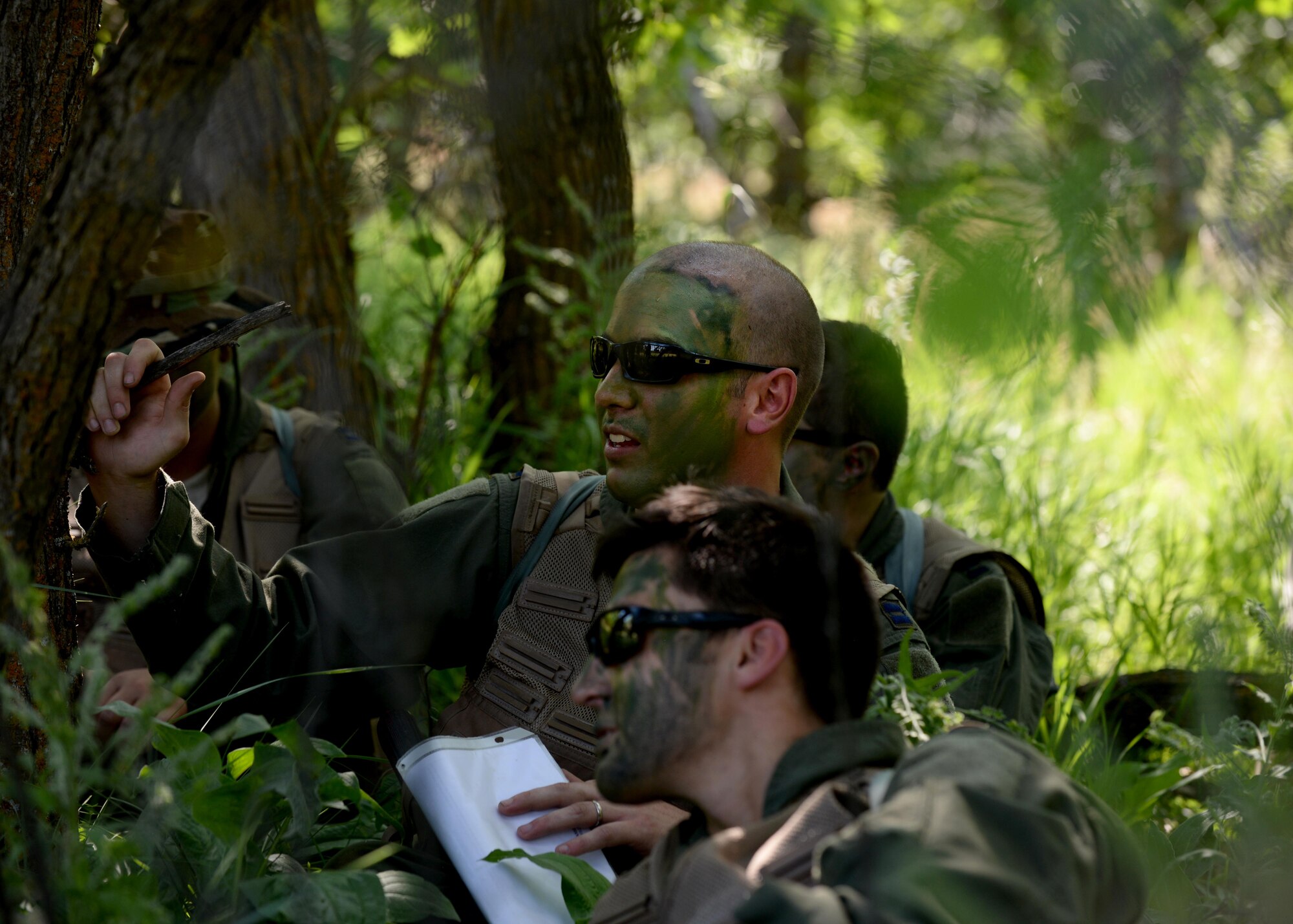 Capts. Korey Schultz, 37th Bomb Squadron weapons system officer, center back, and Matthew Dickerson, center front, 37th BS pilot, hide from simulated enemy forces during Survival, Evasion, Resistance and Escape training near Fort Meade, S.D., June 21, 2016. During the training, several Airmen posed as enemy forces with a goal of detecting the aircrew during their movement to a safe area. (U.S. Air Force photo by Senior Airman Rebecca Imwalle/Released)