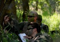 Capts. Korey Schultz, 37th Bomb Squadron weapons system officer, center back, and Matthew Dickerson, center front, 37th BS pilot, hide from simulated enemy forces during Survival, Evasion, Resistance and Escape training near Fort Meade, S.D., June 21, 2016. During the training, several Airmen posed as enemy forces with a goal of detecting the aircrew during their movement to a safe area. (U.S. Air Force photo by Senior Airman Rebecca Imwalle/Released)