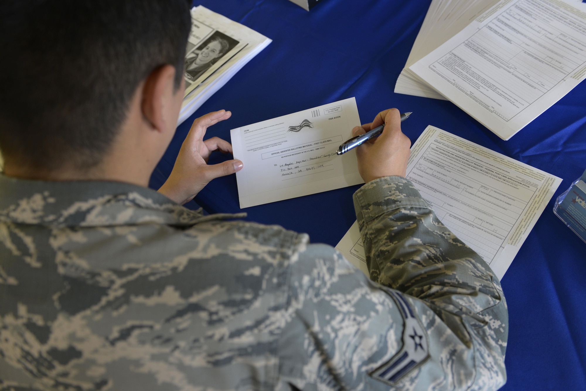 An Airman registers to vote at a voting-assistance table at Joint Base Elmendorf-Richardson, Alaska, June 27, 2016. The Federal Voting Assistance program ensures that overseas citizens and service members are given the opportunity to vote, through absentee ballots. (U.S. Air Force photo by Airman 1st Class Valerie Monroy) 