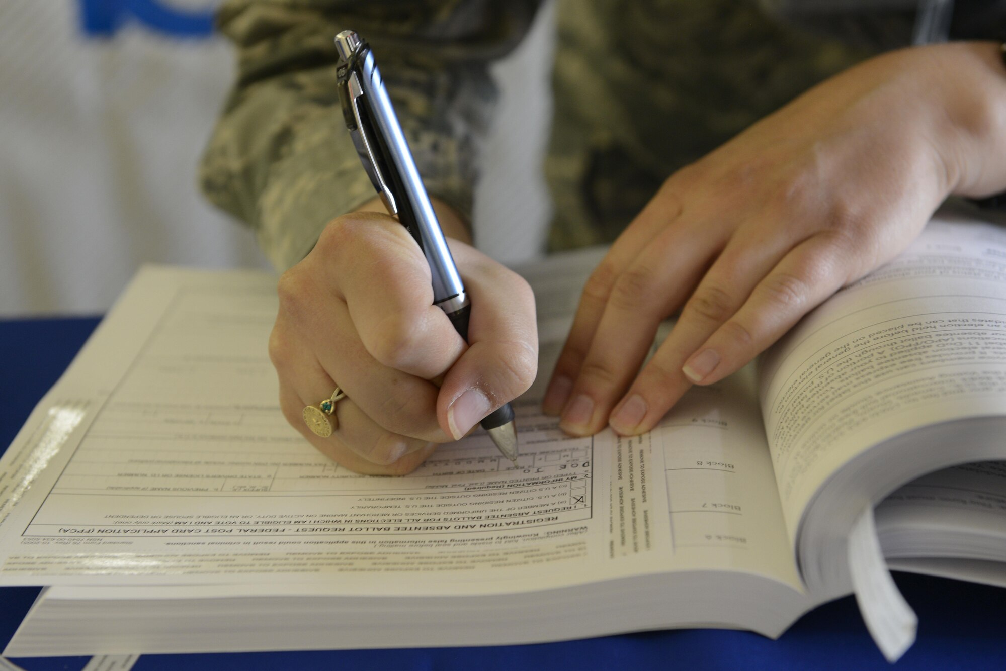 An Airman fills out a Federal Post Card Application at a voting-assistance table at Joint Base Elmendorf Richardson, Alaska, June 27, 2016. The FPCA ensures that the state of residence is informed of the request for an absentee ballot. (U.S. Air Force photo by Airman 1st Class Valerie Monroy)