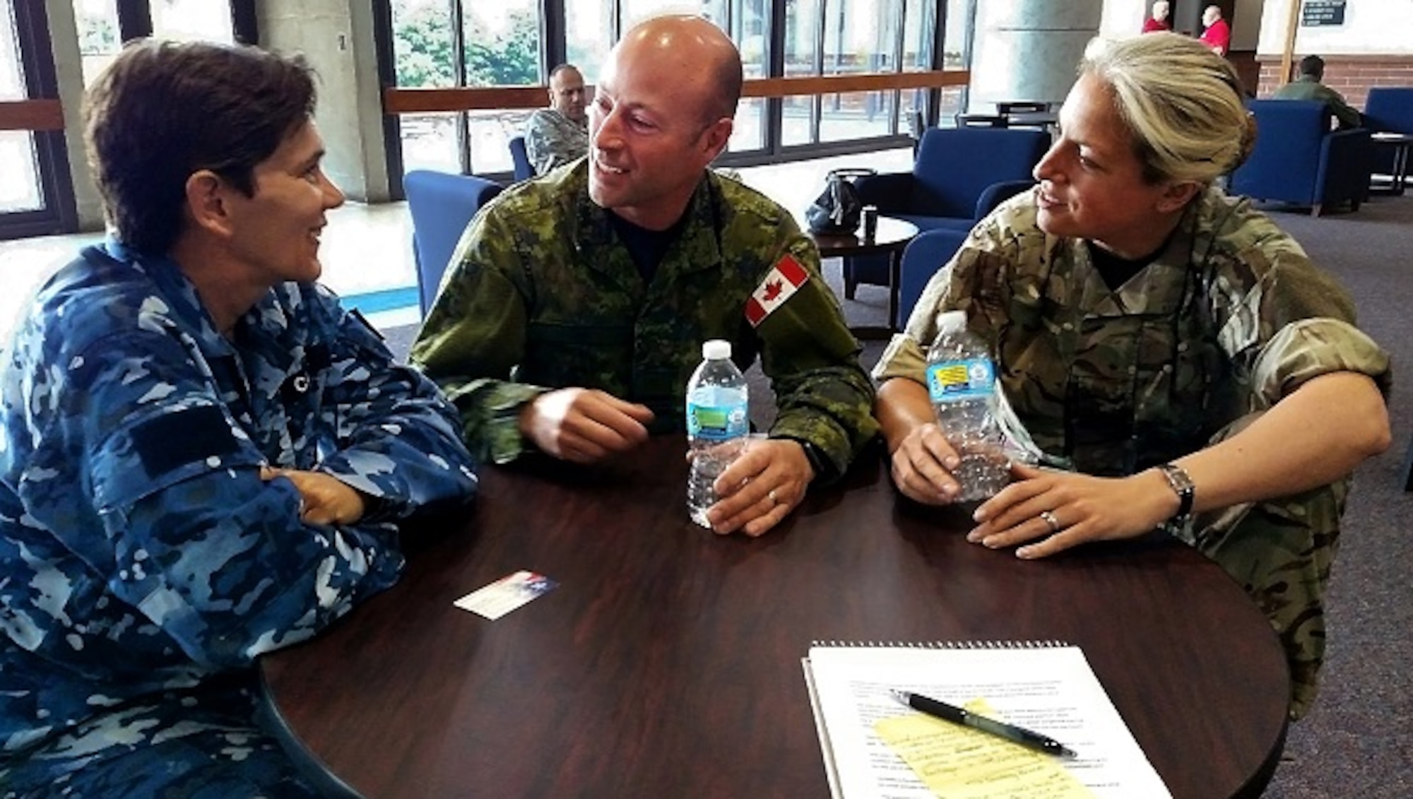 Wing Commmander Kate Carlisle, a logistics officer with the Royal Australian Air Force, Maj. Tony Pepin, the head of doctrine at the Canadian Air Warfare Center, and Squadron Leader Angela Robinson, an officer with United Kingdom's Royal Air Force, chat during a break in action of a wargame at the United States Air Force Expeditionary Center on Joint Base McGuire-Dix-Lakehurst, New Jersey, Jun. 24. The three officers contributed their subject-matter expertise to the wargame known as Global Mobility/Agile Combat Support, or GLOMO/ACS. (U.S. Air Force photo by Senior Master Sgt. Shawn J. Jones)