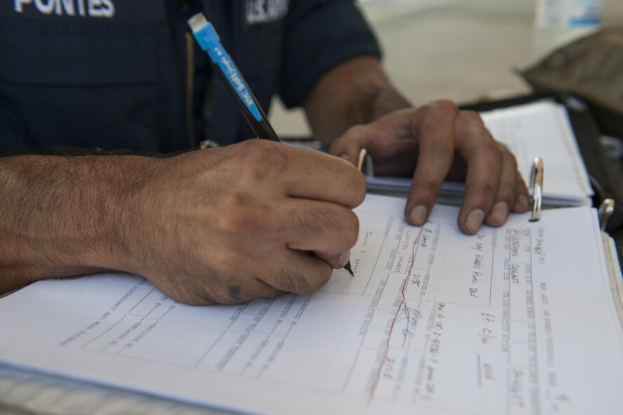 U.S. Air Force Staff Sgt. Brian Pontes, 75th Aircraft Maintenance Unit crew chief, fills out an aircraft form, June 27, 2016, at Moody Air Force Base, Ga. During Col. Thomas Kunkel’s, 23d Wing commander, visit to the 23d Aircraft Maintenance Squadron, he learned about the different responsibilities of a crew chief, including documenting each task in an aircraft forms binder to keep track of maintenance performed on the aircraft. (U.S. Air Force photo by Airman 1st Class Lauren M. Hunter/Released)