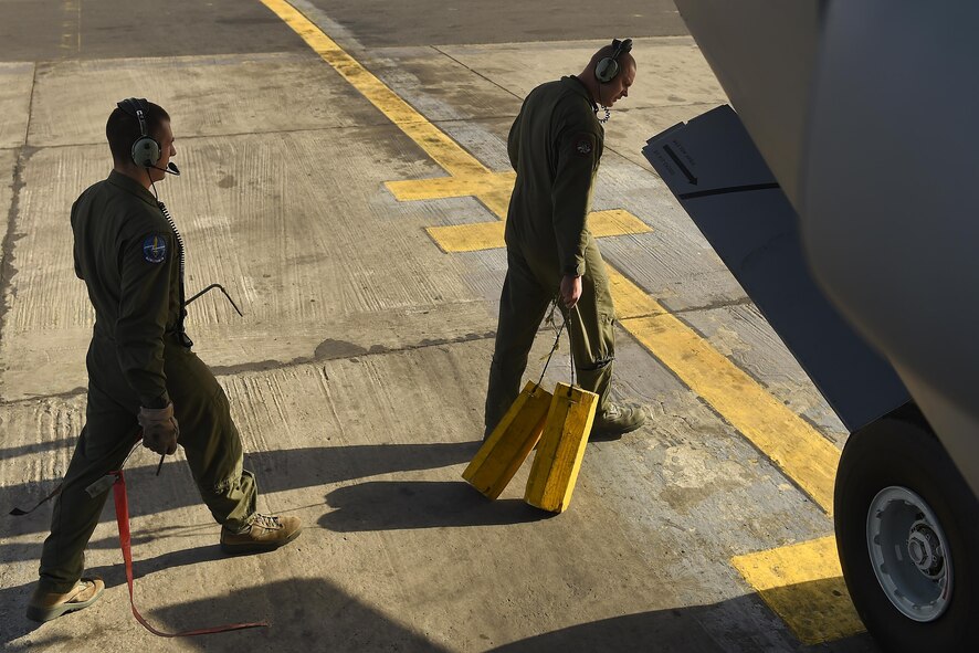 Staff Sgt. Matthew Phillips (left), 62nd Aircraft Maintenance Squadron flying crew chief, secures a C-17 Globemaster III in Senegal, Africa, June 24, 2016. FCCs are responsible for a wide variety of maintenance duties while traveling with the aircraft to include; refueling, paperwork, routine maintenance and troubleshooting major issues. (U.S. Air Force photo/Tech. Sgt. Tim Chacon)