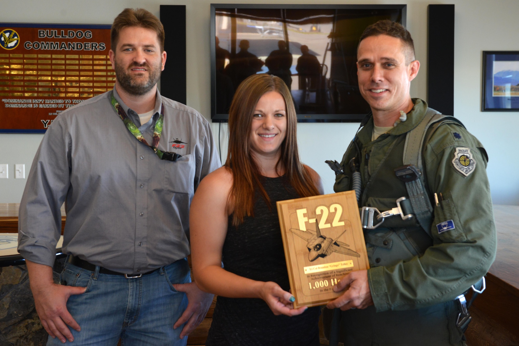 Air Force Lt. Col. Brandon Tellez, 525th Fighter Squadron commander and F-22 Raptor pilot, is presented with a plaque by representatives from Boeing and Lockheed-Martin highlighting his 1,000th-hour milestone. Tellez has been a fighter pilot for 14 years, nine of which were spent flying the Raptor. (U.S. Air Force photo by Airman 1st Class Javier Alvarez)