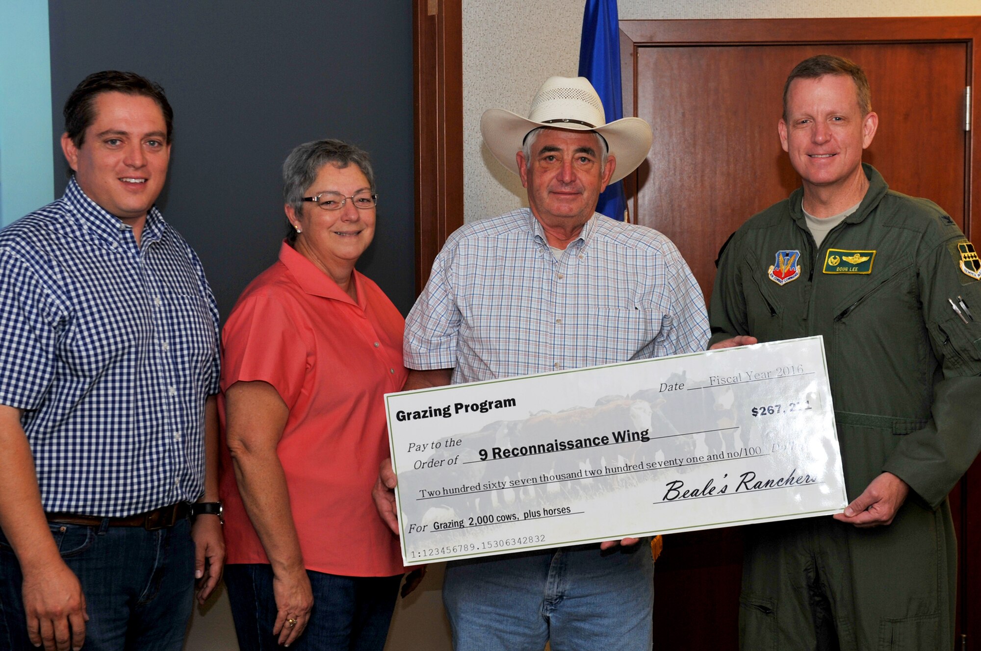 Members of The Schohr Ranch present a check for cattle grazing funds to Col. Douglas Lee, 9th Reconnaissance Wing commander (right) on Beale Air Force Base, California, June 28, 2016. The $267,271 check represents a partnership
between the ranchers and Beale that facilitates the grazing of more than two thousand cattle on the installation. The partnership is the 2nd largest grazing project in the U.S. Air Force and provides both economic stimulus as well as cutting installation maintenance costs. (U.S. Air Force photo by Staff Sgt. Jeffrey Schultze)
