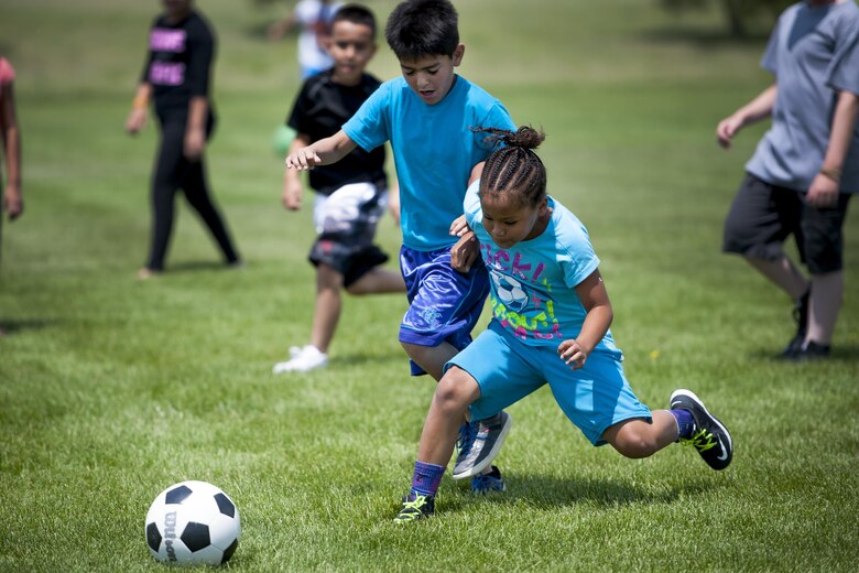 Micheyla Stewart and Joseph Valezuela, Ellicott elementary students, battle for possession of the ball in a soccer game during the Schriever School Age Care Olympic Day at Schriever Air Force Base, Colorado, Wednesday, June 22, 2016. The SAC hosted the event and invited Ellicott summer program youth to participate.  (U.S. Air Force Photo/Dennis Rogers)