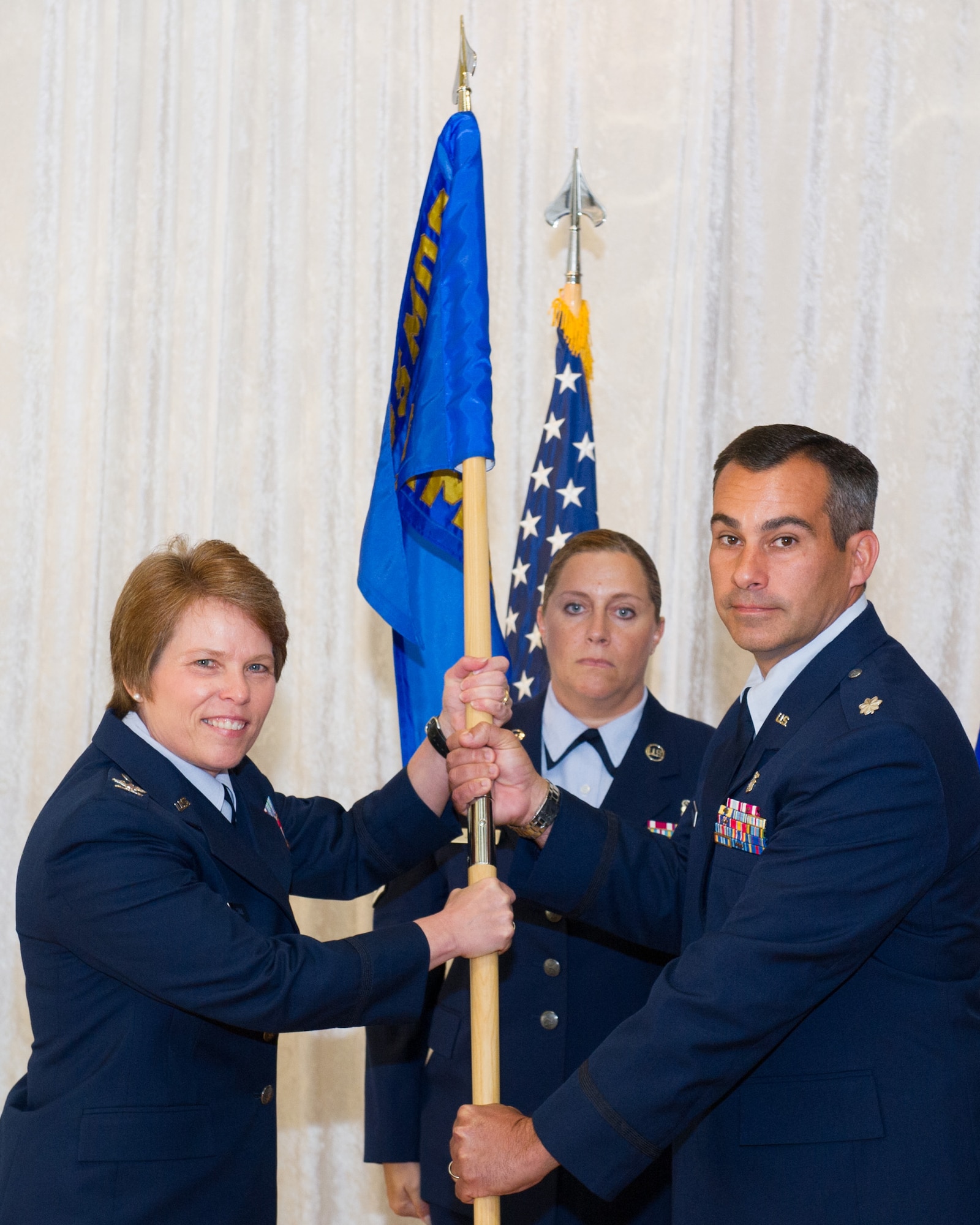 Col. Julie Stola, 45th Medical Group commander, presents Lt. Col. Ian Rybczynski, 45th Aerospace Medicine Squadron commander, with the guidon during a change of command ceremony June 28, 2016, at Patrick Air Force Base, Fla. Changes of command are a military tradition representing the transfer of responsibilities from the presiding official to the upcoming official. (U.S. Air Force photo/Matthew Jurgens/Released)
