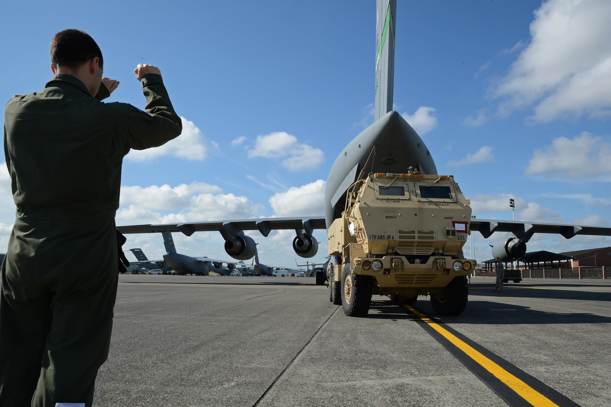 Senior Airman Patrick Bullard, 7th Airlift Squadron loadmaster, directs the crew of a High Mobility Artillery Rocket System as they load the vehicle onto a C-17 Globemaster III aircraft prior to a rapid infiltration HI-RAIN exercise June 22, 2016 at Joint Base Lewis-McChord, Wash. Each vehicle had to be carefully loaded to meet precise weight and balance standards for the aircraft. (U.S. Air Force photo/Senior Airman Jacob Jimenez) 