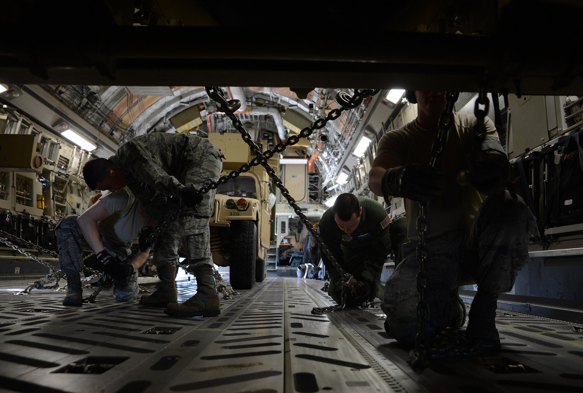 Airmen from the 62nd Aerial Port Squadron and the 7th Airlift Squadron chain down a High Mobility Artillery Rocket System on a C-17 Globemaster III aircraft June 22, 2016, at Joint Base Lewis-McChord, Wash. Each vehicle had to be chained down according to technical orders so they wouldn’t move during the flight to Moses Lake, Wash., for a rapid infiltration HI-RAIN exercise. (U.S. Air Force photo/Senior Airman Jacob Jimenez) 