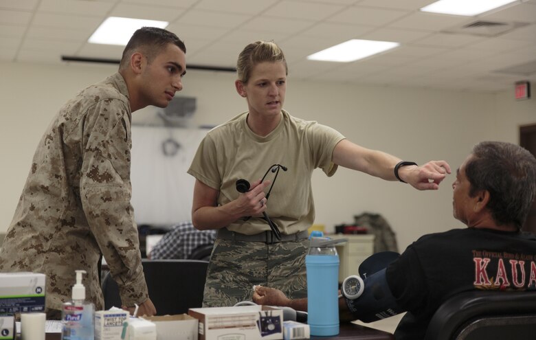 Lance Cpl. Alex A. Dossantos (left), a supply administration and operations specialist with 4th Dental Battalion, 4th Marine Logistics Group, Marine Forces Reserve, learns how to conduct basic medical screenings from Air Force Staff Sgt. Keri L. Christian (right), a medical training manager with 190th Medical Group, 190th Air Refueling Wing, Air National Guard, at Kauai Community College during Innovative Readiness Training Tropic Care 2016, June 25, 2016. Dossantos studies biology and psychology at the University of Georgia in Athens, Ga., and hopes to pursue a career in neurology. IRT Tropic Care 2016 is part of a civil and joint military program to improve military readiness while simultaneously providing quality services to underserved communities throughout the United States. (U.S. Marine Corps photo by Sgt. Ian Leones/Released)
