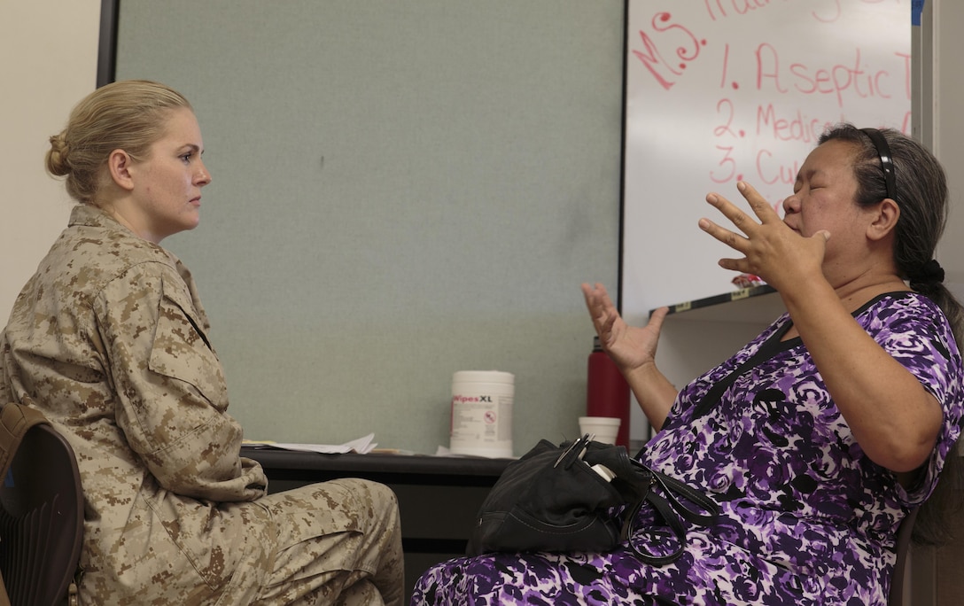 Lt. Cmdr. Heather J. Sterk (left), a psychologist and officer in charge of Company A, 4th Medical Battalion, 4th Marine Logistics Group, Marine Forces Reserve, listens to a patient at Kapaa Middle School during Innovative Readiness Training Tropic Care 2016, June 25, 2016. As part of the training, Sterk provides patients with basic behavioral health services such as help with sleep hygiene, stress management techniques, initial diagnosis and referral services. IRT Tropic Care 2016 is part of a civil and joint military program to improve military readiness while simultaneously providing quality services to underserved communities throughout the United States. (U.S. Marine Corps photo by Sgt. Ian Leones/Released)