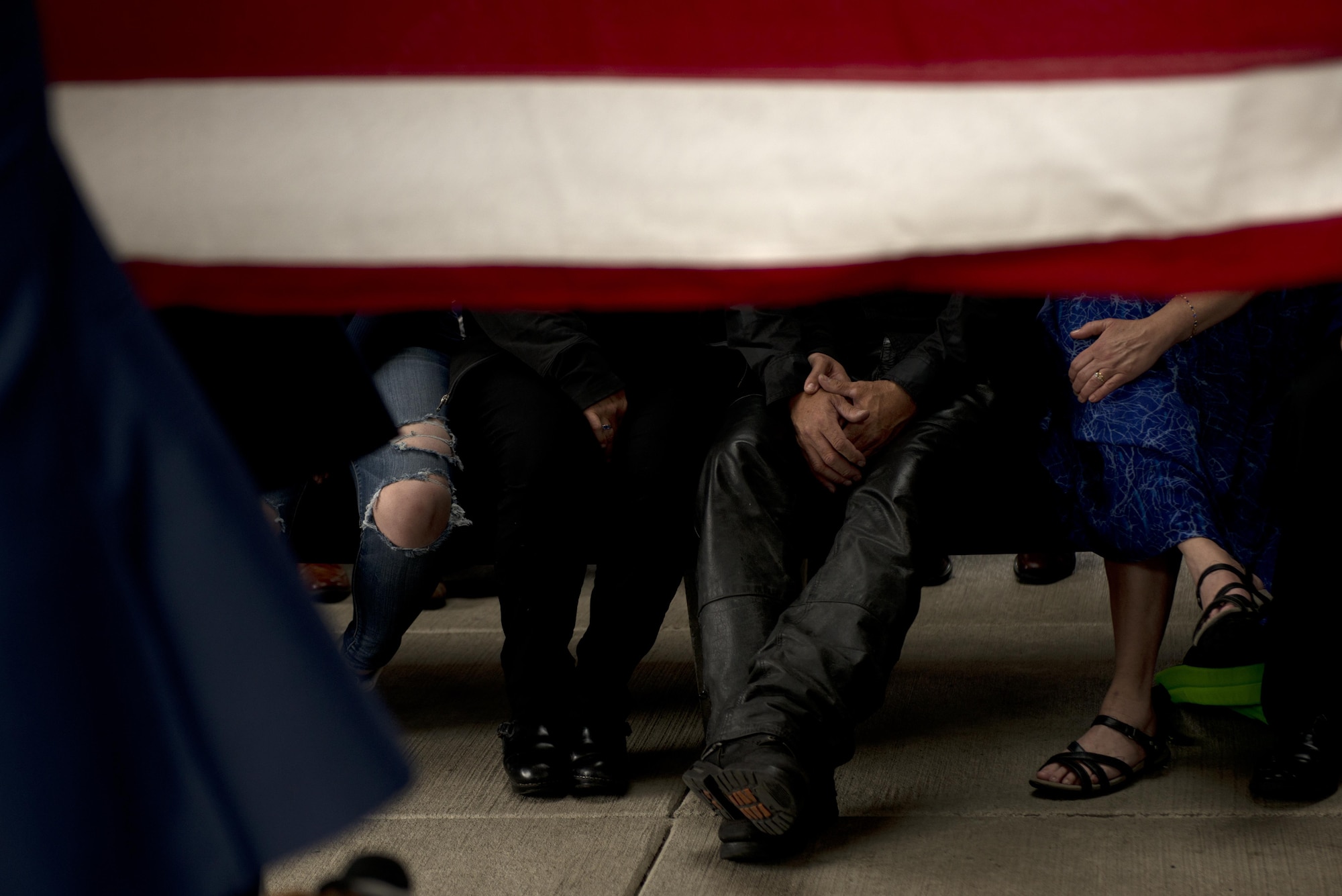 Family of Fred "Bulldog" Becker IV watch a flag-folding ceremony by the Joint Base Elmendorf-Richardson Honor Guard June 24. Bulldog was heavily involved in the Anchorage community, and more than 1,000 Airmen and Soldiers lined the streets for his processional, consisting of hundreds of motorcyclists from around the community. (U.S. Air Force photo by Senior Airman Kyle Johnson)