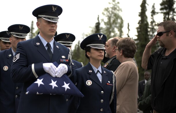 The Joint Base Elmendorf-Richardson Honor Guard carries a folded American flag into the funeral ceremony for Fred "Bulldog" Becker IV June 24. Bulldog was heavily involved in the Anchorage community, and more than 1,000 Airmen and Soldiers lined the streets for his processional, consisting of hundreds of motorcyclists from around the community. (U.S. Air Force photo by Senior Airman Kyle Johnson)