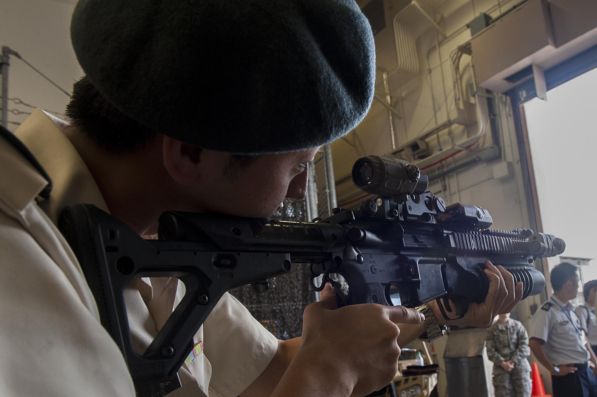 Japan Ground Self-Defense Force 1st Lt. Akifumi Saito, UH-1 pilot attending the 52nd Joint Tactical Operations Course, tries holding weapons from the 320th Special Tactics Squadron during a tour of the 353rd Special Operations Group June 21, 2016, at Kadena Air Base, Japan. Japan Air Self-Defense Force and JGSDF members use the tour of Kadena to learn about the U.S. Air Force and exchange knowledge between the two countries. (U.S. Air Force photo by Airman 1st Class Corey M. Pettis)