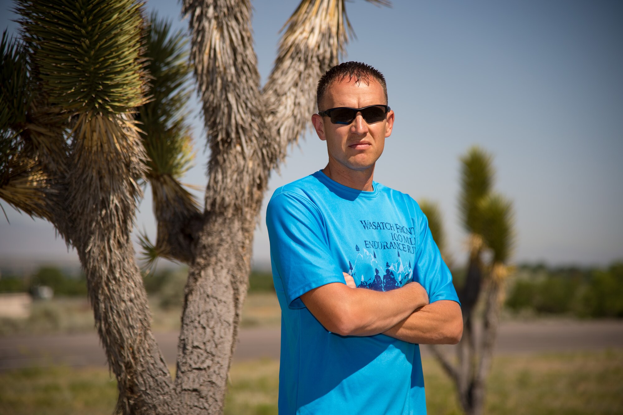 Capt. Jared Struck, an aircraft maintenance officer assigned to the Ogden Air Logistics Complex, poses before Joshua trees at Hill Air Force Base, Utah, June 27. Struck is training to run the Badwater ultramarathon in July. To prepare for the 135-mile race, he runs 6 days and lifts 3 to 4 days per week. (U.S. Air Force photo by R. Nial Bradshaw)
