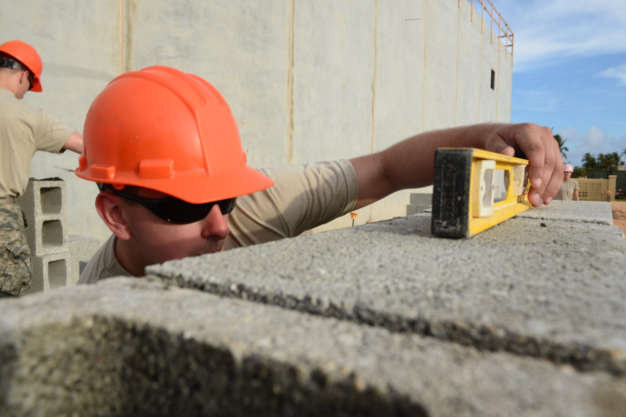 U.S. Air Force Senior Airman Ben Raymond, with the 157th Civil Engineering Squadron, New Hampshire Air National Guard, check the level of a cinder block while building a wall as part of the Commando Warrior Field Training Facility, Andersen Air Force Base, Guam, June 20, 2016. 157 CES Airmen are deployed to Guam for annual training where they are working on a construction project for the Pacific Command Regional Training Center.(Air National Guard photo by Airman 1st Class Ashlyn J. Correia) 