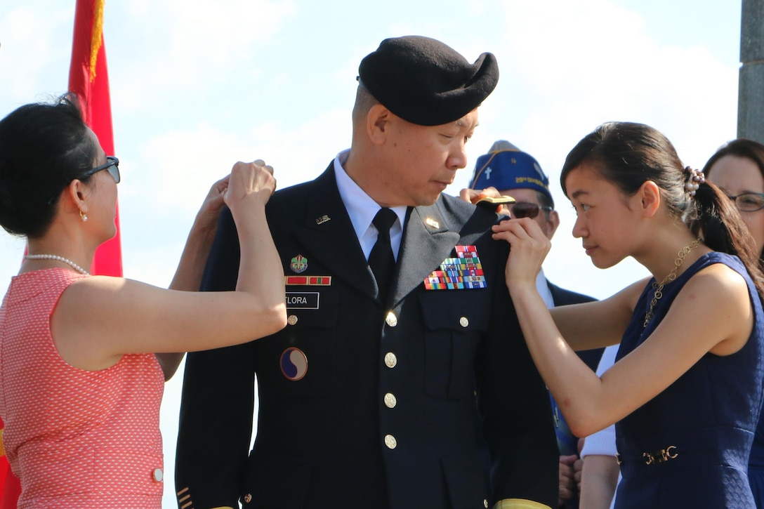 Thuy Flora, left, and Christine Flora, right, promote Lapthe C. Flora to brigadier general, June 6, 2016, at the National D-Day Memorial in Bedford, Virginia. Virginia Army National Guard photo by Cotton Puryear
