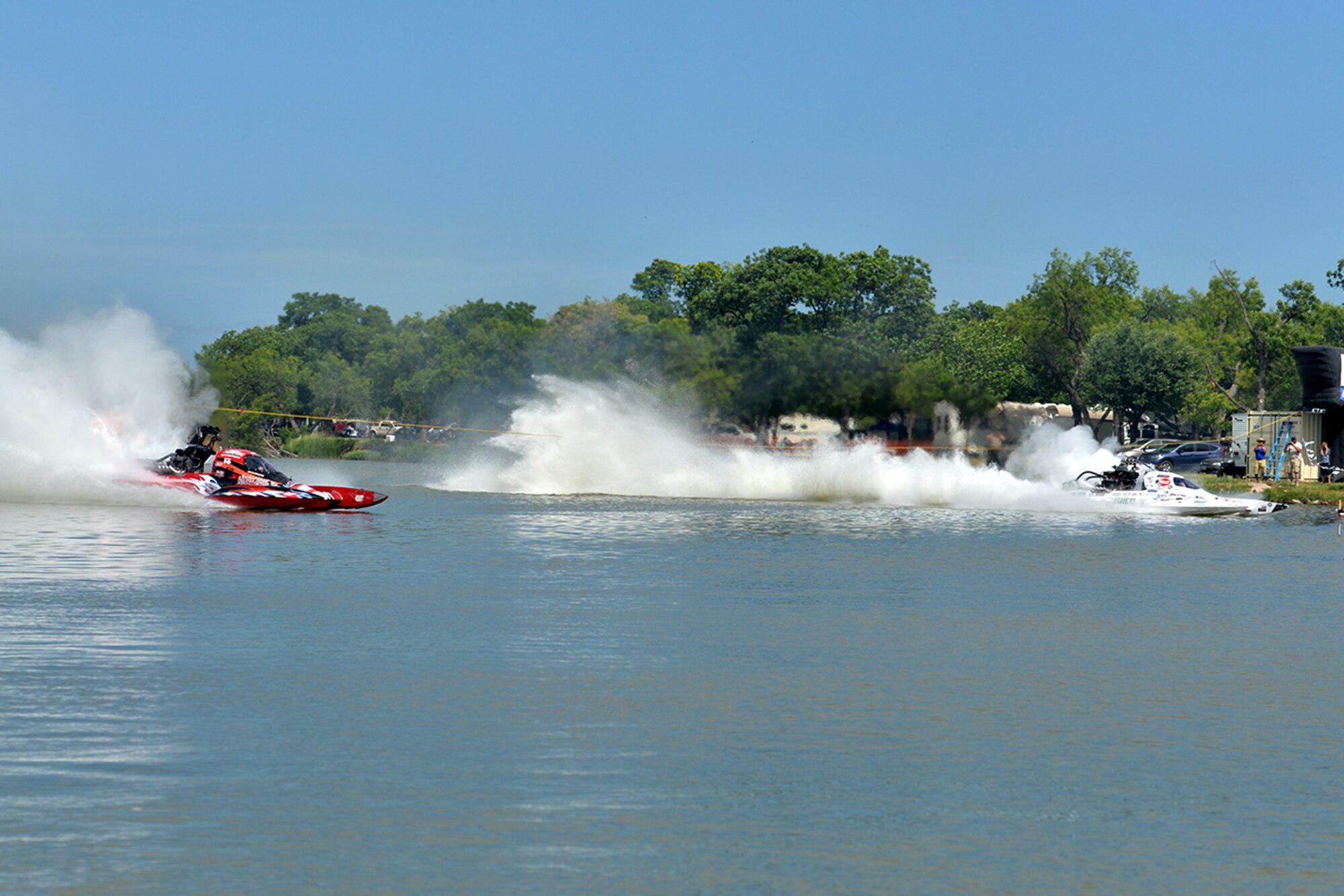 Drag boat drivers race in a liquid quarter mile during the 2016 Showdown in San Angelo Super Nationals drag boat races at Lake Nasworthy, San Angelo, Texas, June 25, 2016. The Showdown brings in people from around the nation and the Goodfellow volunteers ensure that the lake was kept clean. (U.S. Air Force photo by Airman 1st Class Randall Moose/Released)