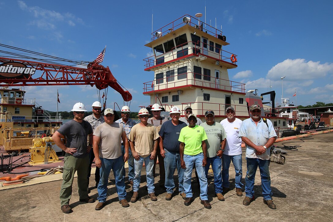The Tulsa District U.S. Army Corps of Engineers navigation maintenance vessel Captain and crew stand in front of their boat, Mr. Pat, near Sallisaw, Oklahoma, June 15, 2016. Mr. Pat was christened and put into service at the District on June 28, 1996, and for the past 20 years has been instrumental in the facilitation of maintenance along the Tulsa District's portion of the McClellan-Kerr Arkansas River Navigation System. (U.S. Army Corps of Engineers photo by Preston Chasteen/Released)