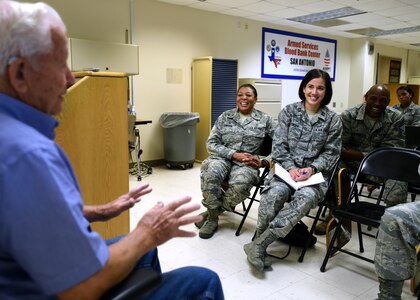 Retired Tech. Sgt. Arnold Parker (left), a Korean War veteran who worked in nutritional medicine on Lackland Air Force Base, Texas, in the early 1950s, speaks with members of the 59th Diagnostics and Therapeutics Squadron during a session of the Deliberate Development Program June 20 at the Armed Services Blood Bank Center, Joint Base San Antonio-Lackland, Texas. The program develops Airmen of all ranks in areas, which include leadership, management and self-improvement. It encourages networking and access to other members of the medical team. (U.S. Air Force photo/Staff Sgt. Kevin Iinuma)